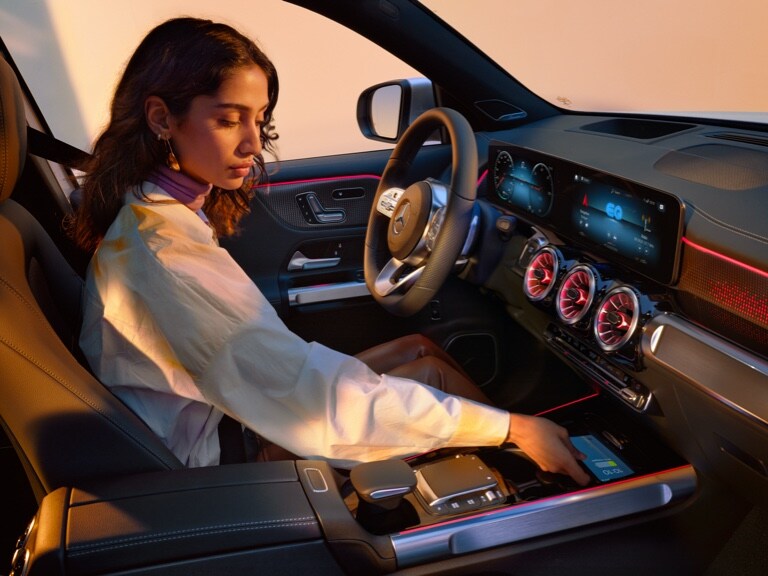 一位女仕在她 Mercedes-Benz 的置物台上將她的智慧型手機無線充電。