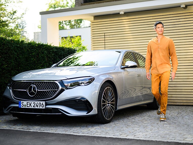 A person walking away from a Mercedes-Benz vehicle looking into the distance. 一個人走離賓士車並看向遠方
