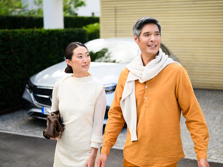 Two people walking away from a Mercedes-Benz vehicle and looking into the distance. 兩個人走離賓士車並看向遠方