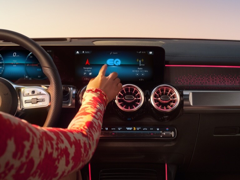 一位女仕在 Mercedes-Benz MBUX 多媒體系統上啟動導航。
