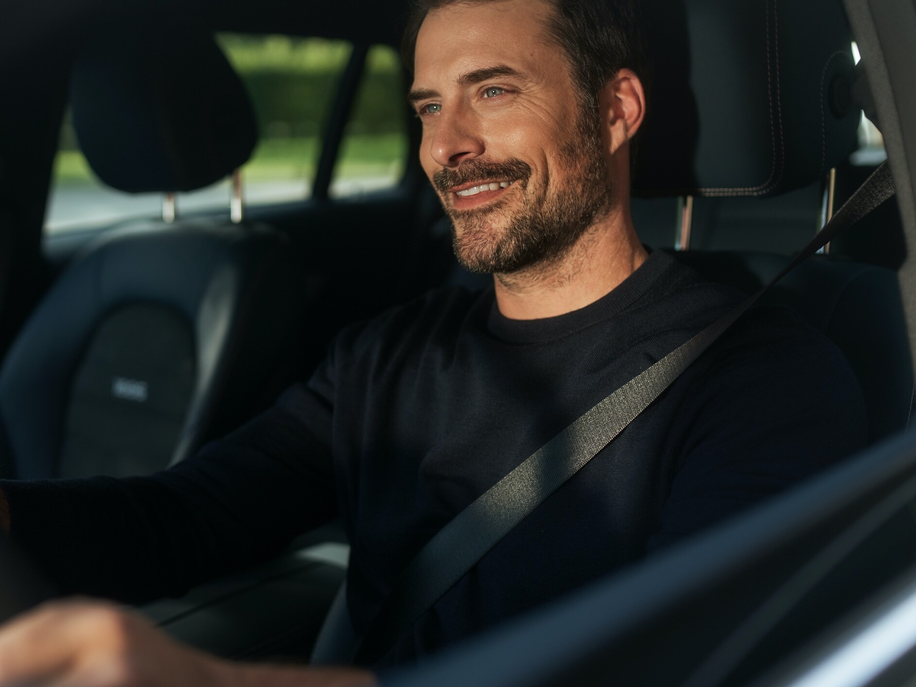 一位男仕在其車上使用 MBUX 使用語音助理。