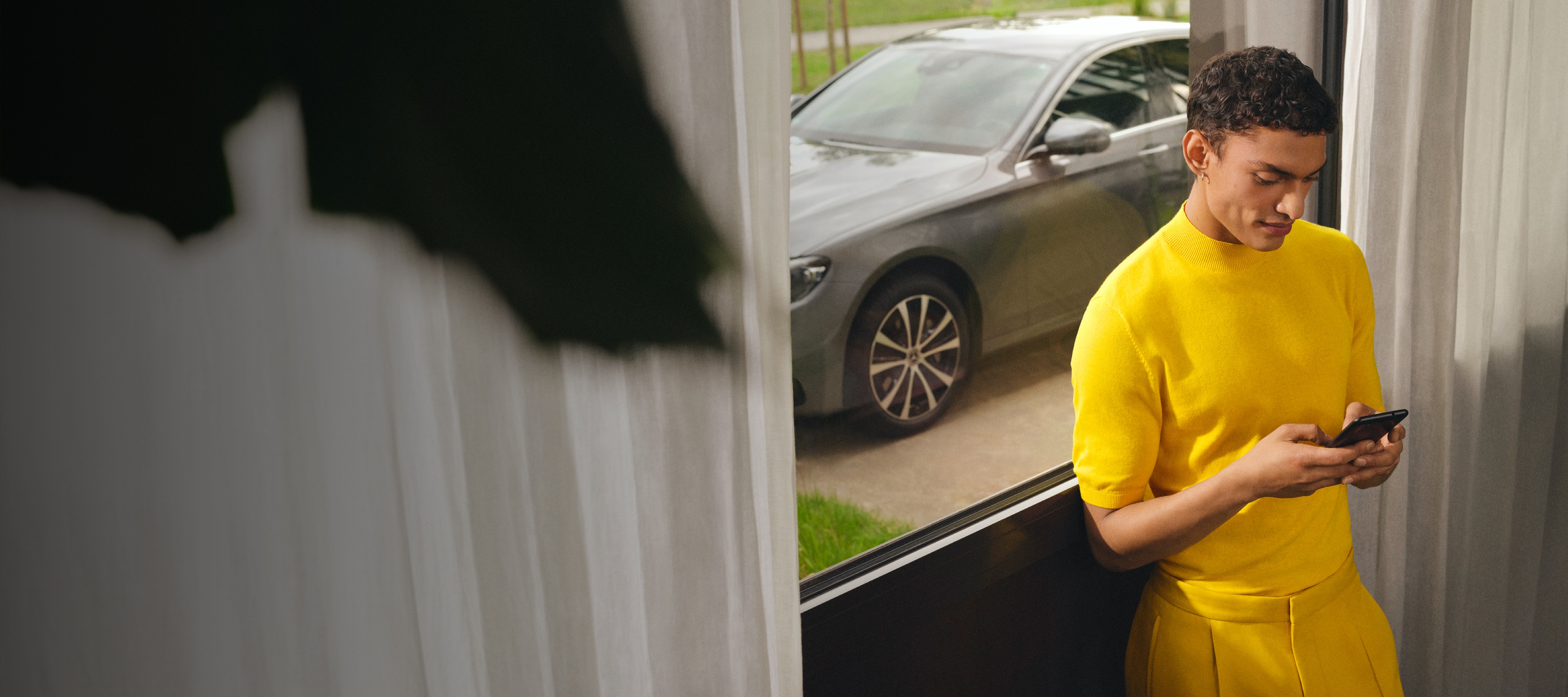 Mercedes-Benz App | Mercedes-Benz 一名男仕使用智慧型手機透過數位增訂與他的 Mercedes-Benz 連接。
