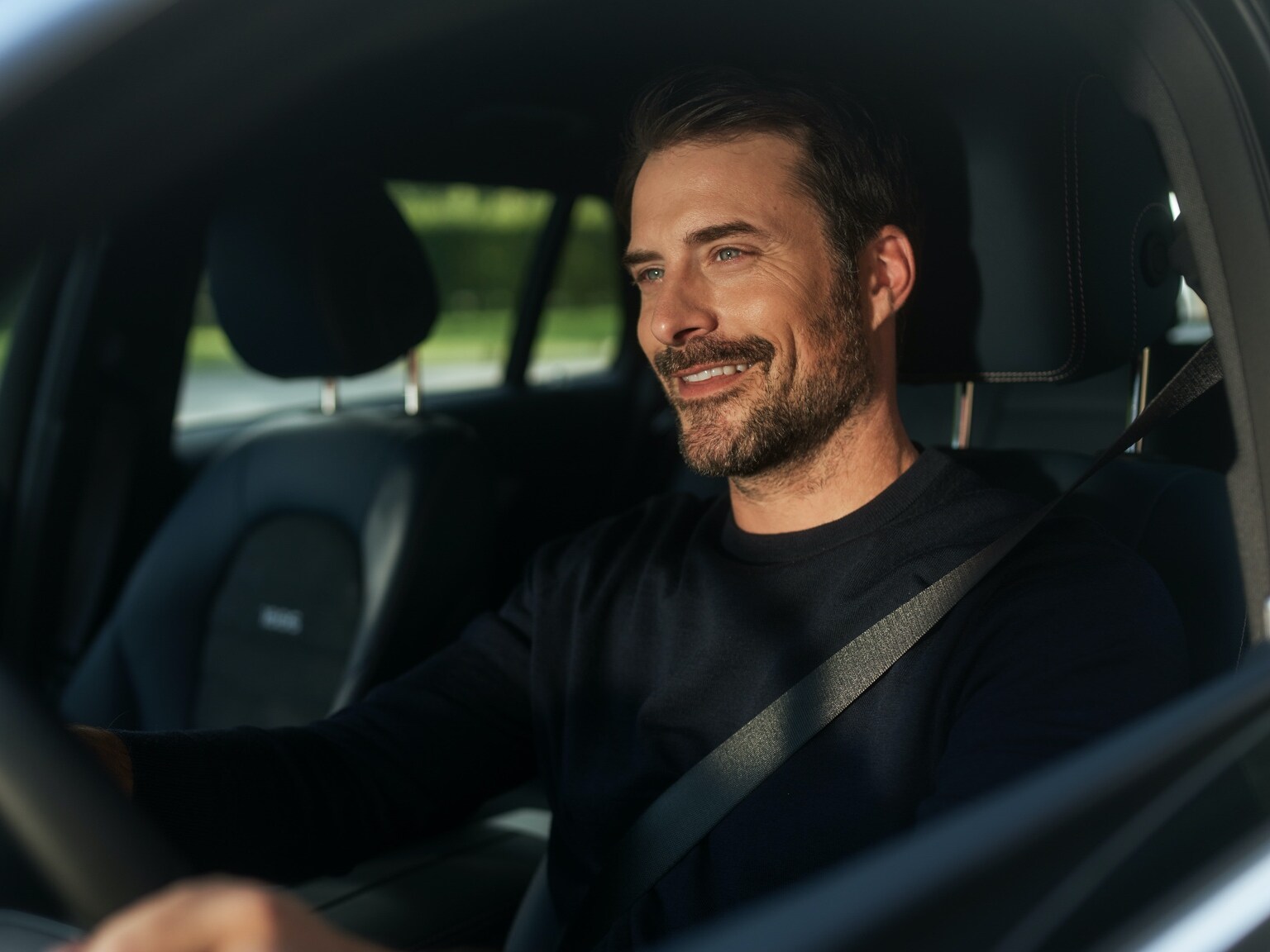 一位男仕在他的 Mercedes-Benz 中藉助娛樂套件享受無中斷的網路收音機。